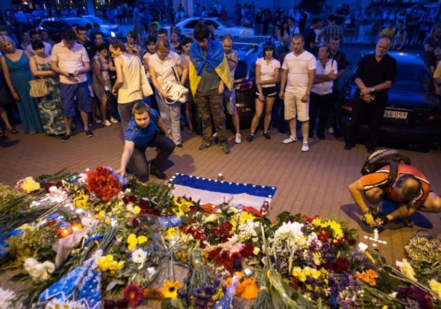 La tristezza della gente riunitasi davanti all&#39;ambasciata olandese a Kiev per deporre fiori e accendere ceri per i morti della strage aerea. Epa